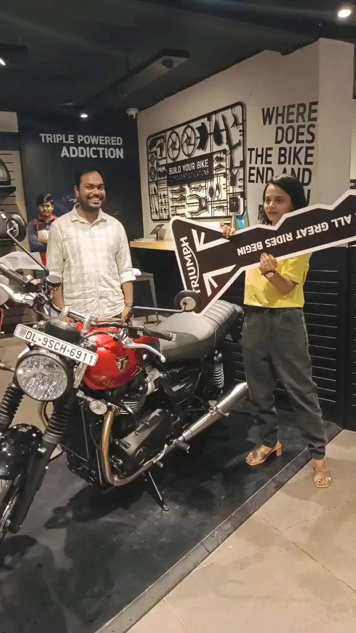 Wife holding the Triumph ceremonial key at the showroom { w: 600, h: 400 }